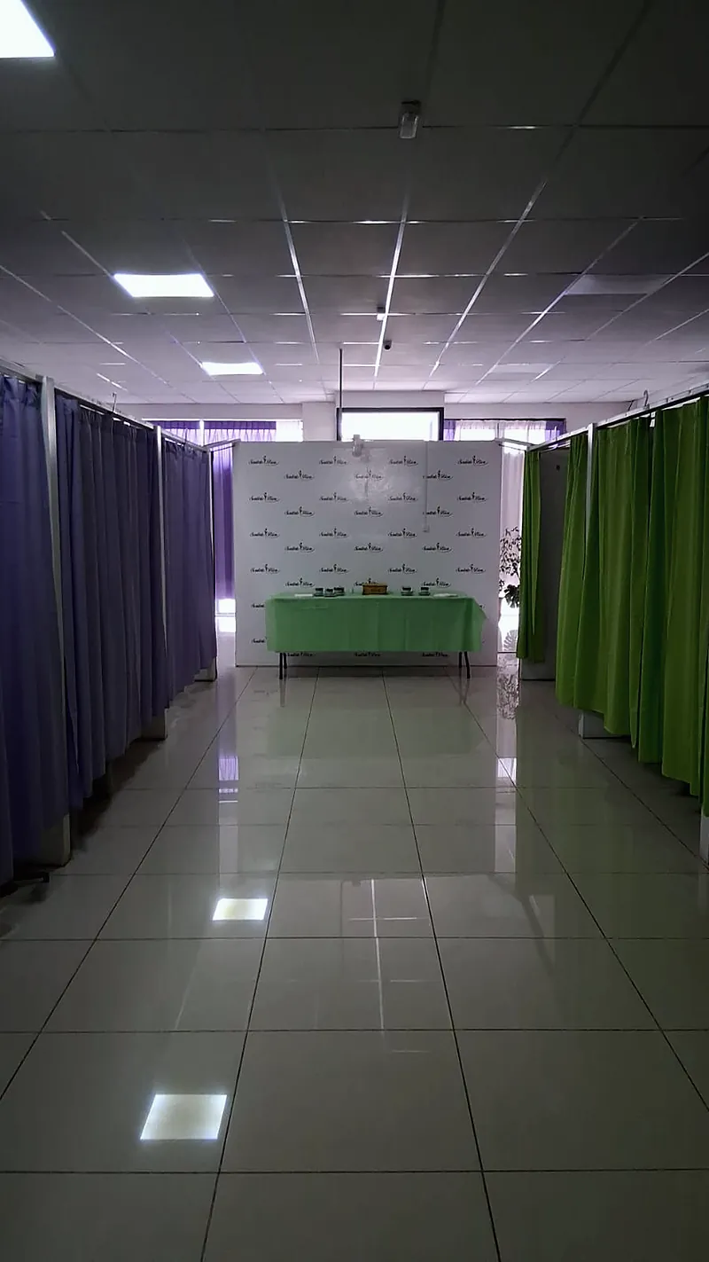 Pasillo de cabinas de Sentirte Bien en Maipú, con la mesa de productos frente al panel del centro
